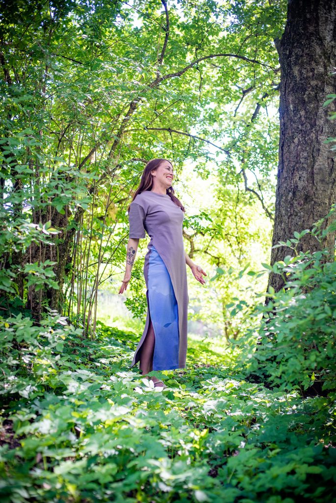Jente i lilla og blå kjole i skogen